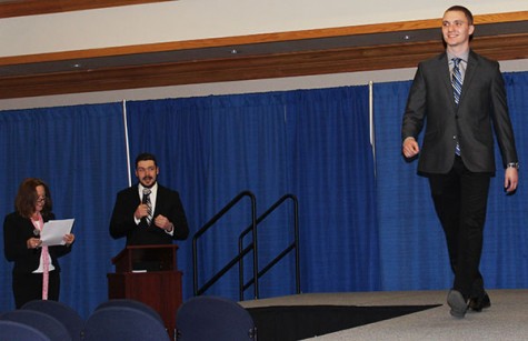 Event masters of ceremony associate professor Kristen Majocha and sophomore Shane McGuire introduce junior Michael Shields as he walks the runway.