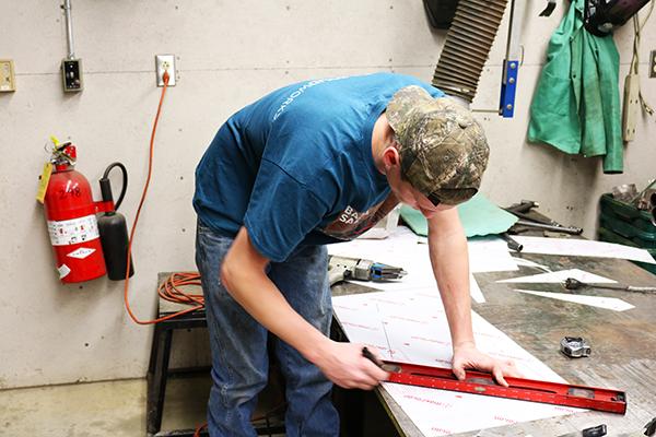 Senior Randy Moore works Thursday evening in a garage connected to the Physical Plant building.