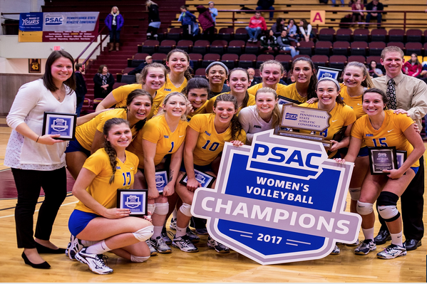 Members of the Pitt-Johnstown volleyball team celebrates with their trophy and plaques after defeating Gannon University in the conference championship Nov. 18 at the Hammermill Center in Erie, Pa.