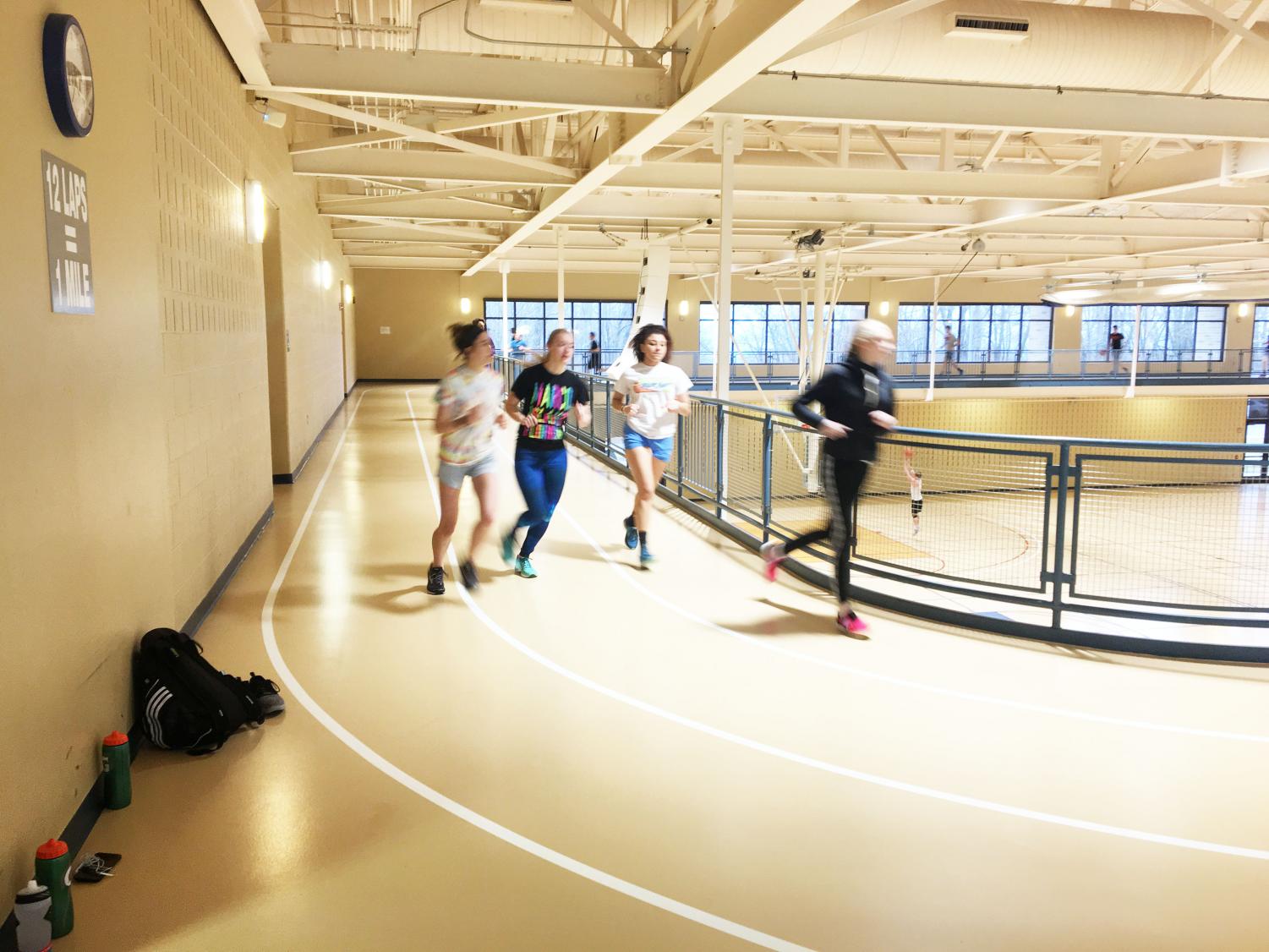 Track team members (left to right) Samantha Klutz, Alana Thomas, Taylor Briscoe and Samantha Miller run laps around the track in the Wellness Center last Friday.