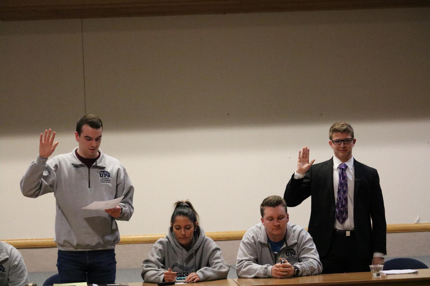 Former student government President Joe Evanko (left) swears in his successor Sam Miller (right) as president.