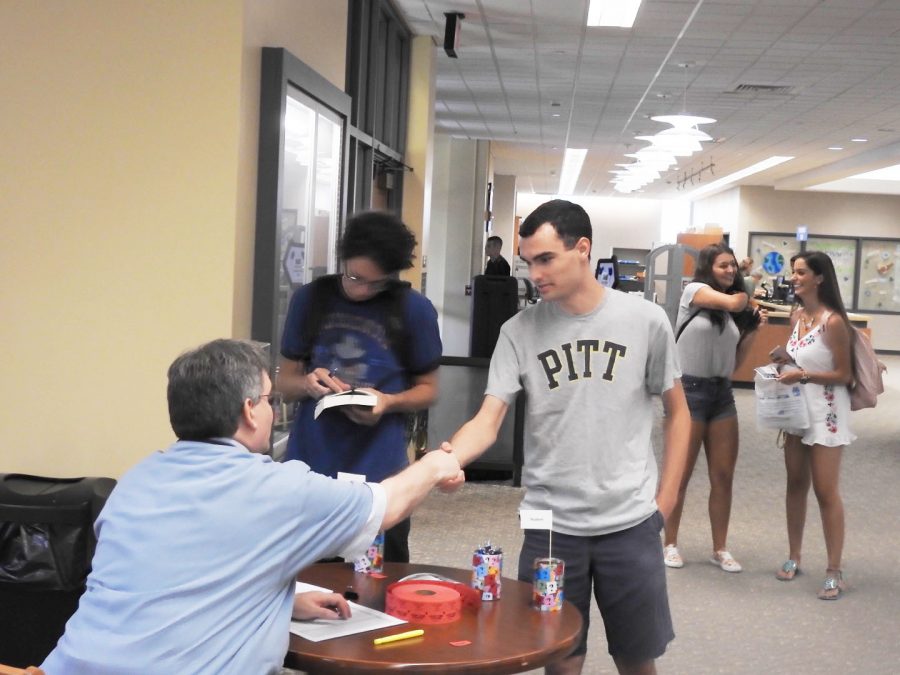 Sophomore+Matt+Stark+shakes+hands+with+Owen+Library+director+Peter+Egler+at+an+Aug.+30+open+house.+Egler+said+that%2C+eventually%2C+all+students+will+go+through+the+personal-librarian+program+during+their+first+year.