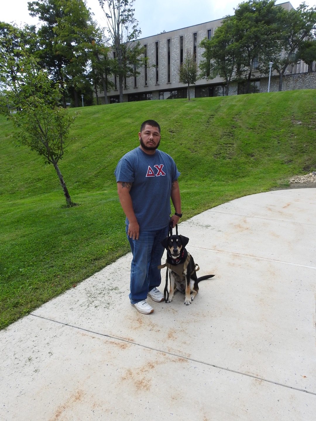 Junior Justin Sprinkle and his service animal, Clyde, standing outside the Nursing and Health Sciences building Aug. 30.