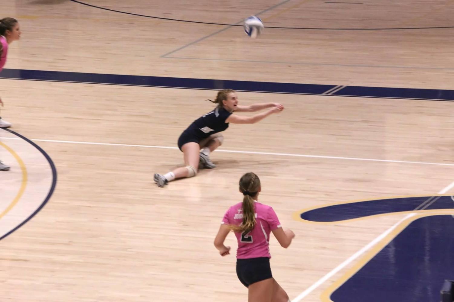 Erin Carmody (in black) saves the ball as teammate J.C. Longeville (toward foreground) watches in a match against Lock Haven in the Sports Center Oct. 12.