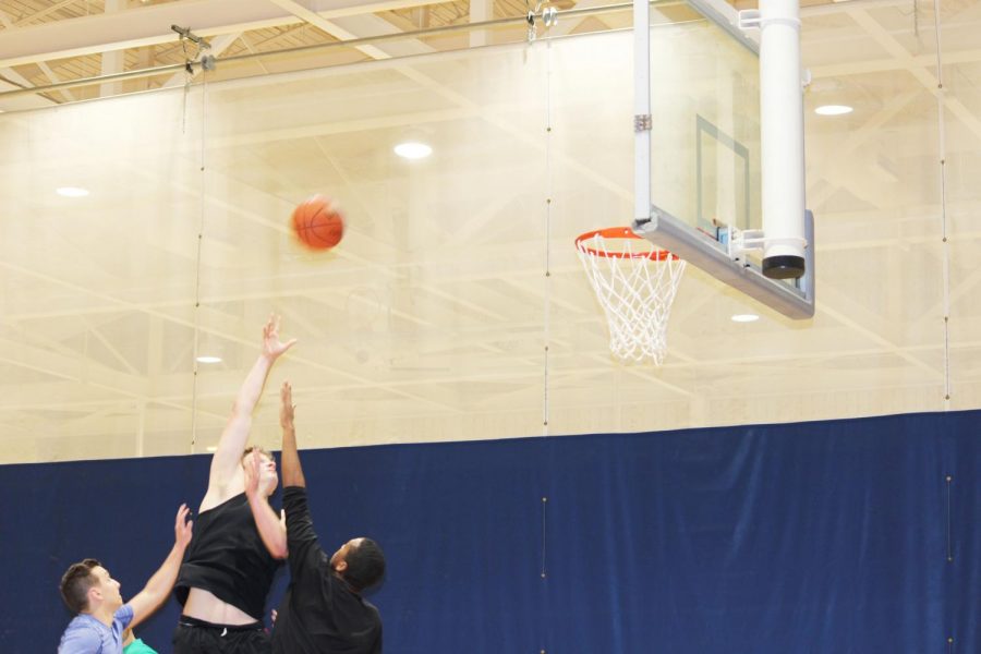 Matt+Holsinger+shoots+the+ball+against+two+oppenents+at+the+three+vs+three+basketball+helping+Melo+is+Trash+winning+the+game+Jan.+28+in+the+Wellness+Center.